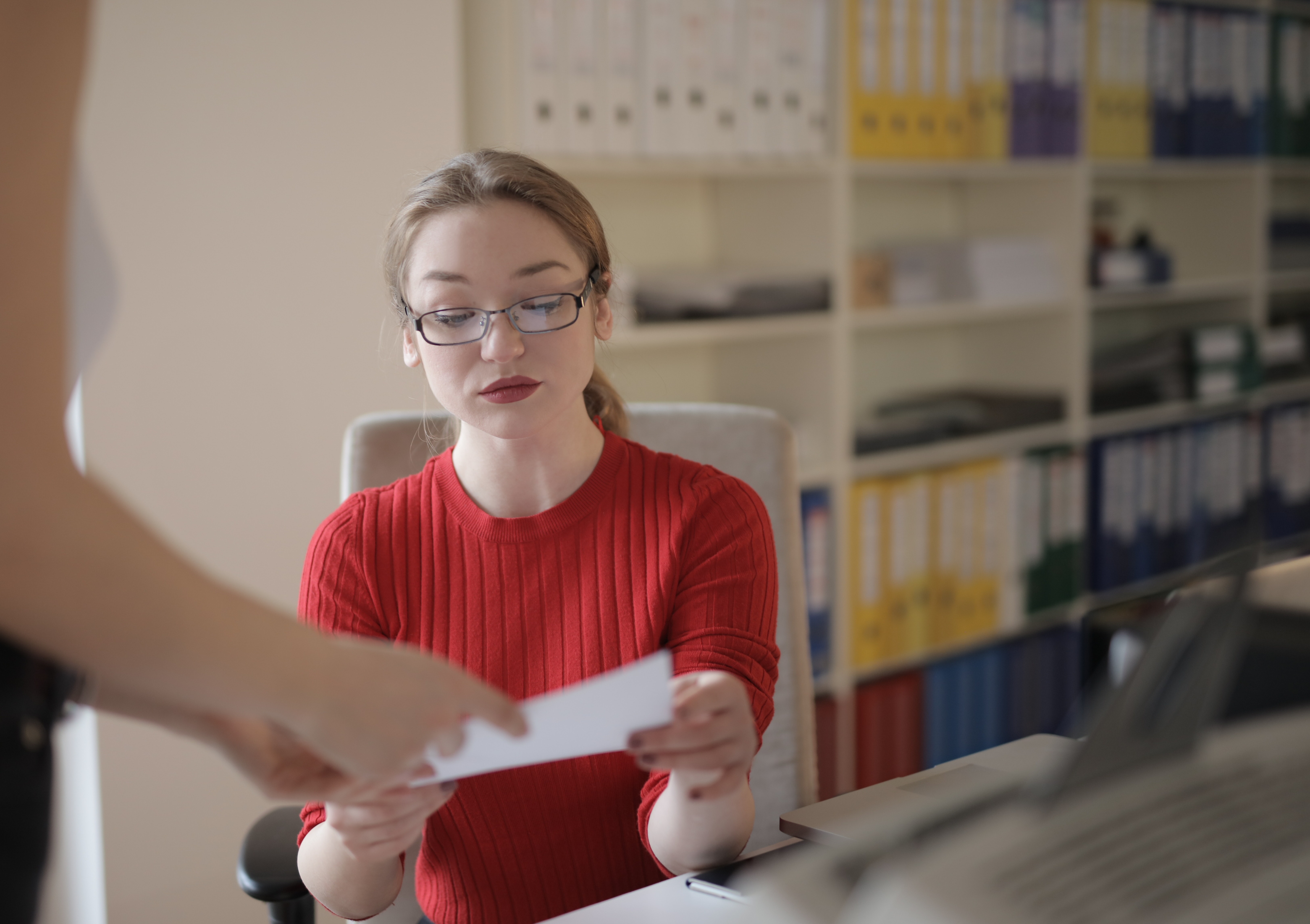 young-woman-examining-document-in-office