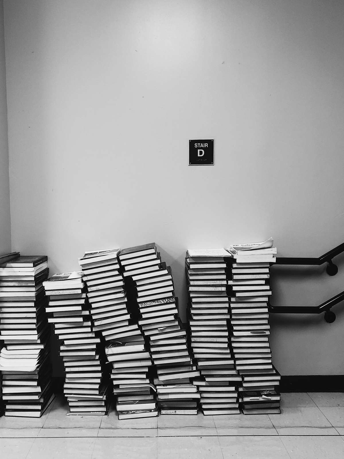 grayscale photography of pile of books