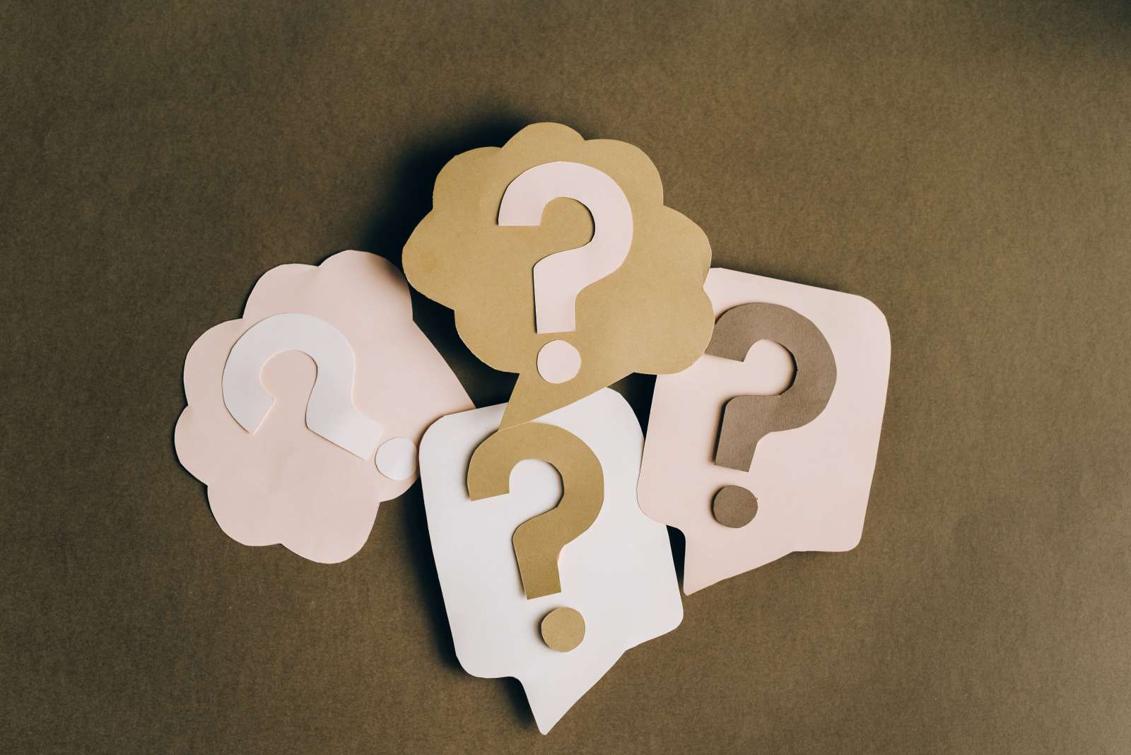 A picture of four question mark cutouts on paper